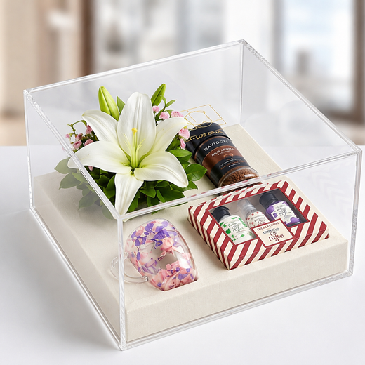 Corporate gift hamper in a clear acrylic box with flowers, coffee and gift set