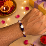 Sukoon Crystal Rakhi worn on brother's wrist — Amethyst, Howlite and Clear Quartz natural gemstone rakhi by Celebration Kraft